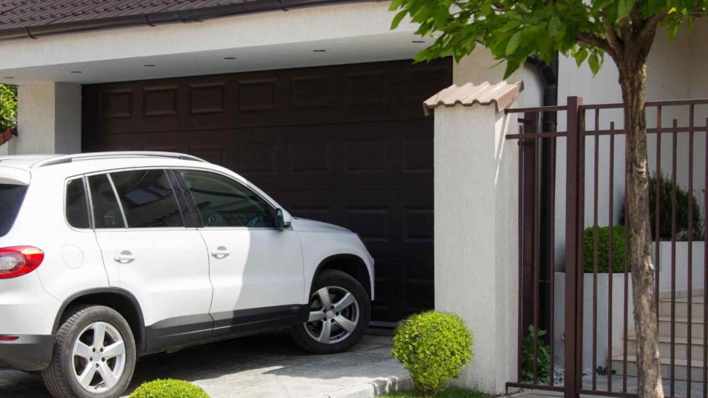A white car is awaiting the garage door to open.