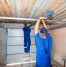 Two professionals are installing a garage door.