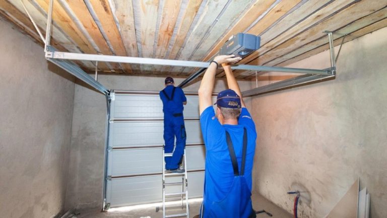Two professionals are installing a garage door.