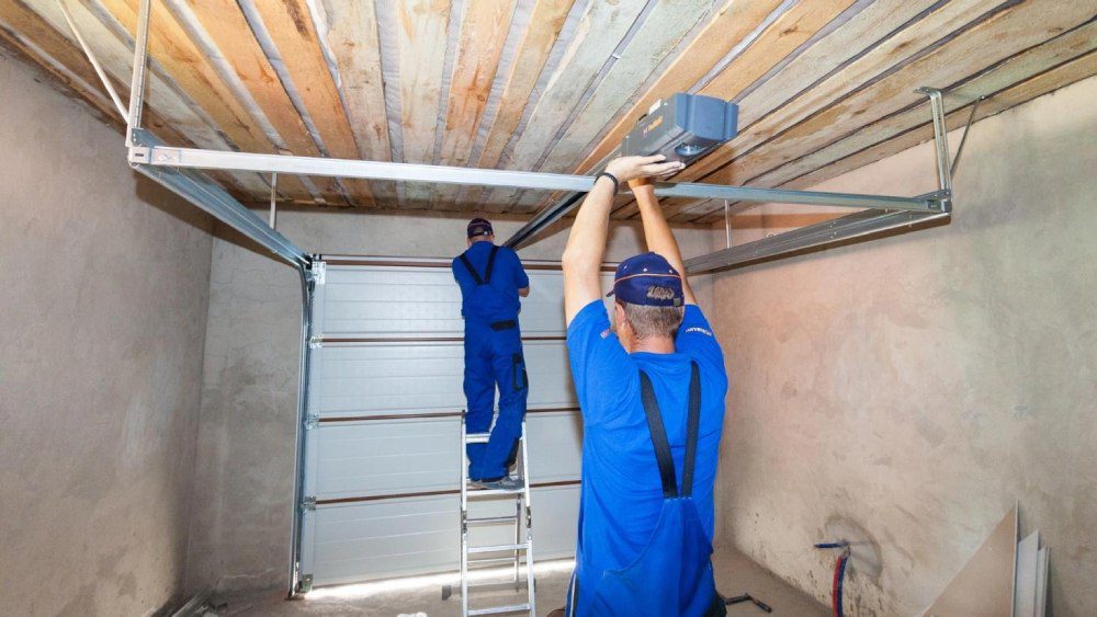 Two professionals are installing a garage door.